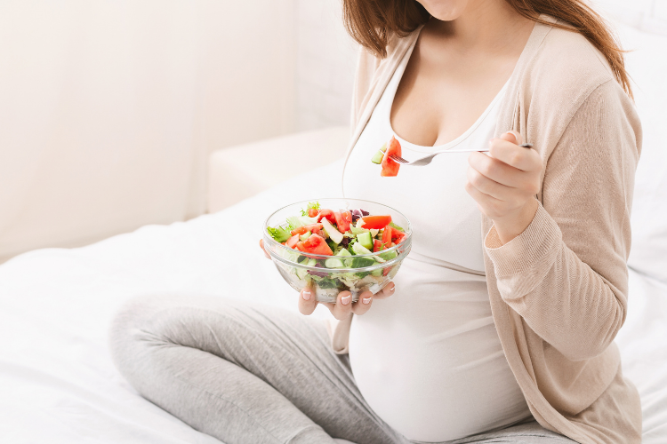 woman with a babybelly eating a salad